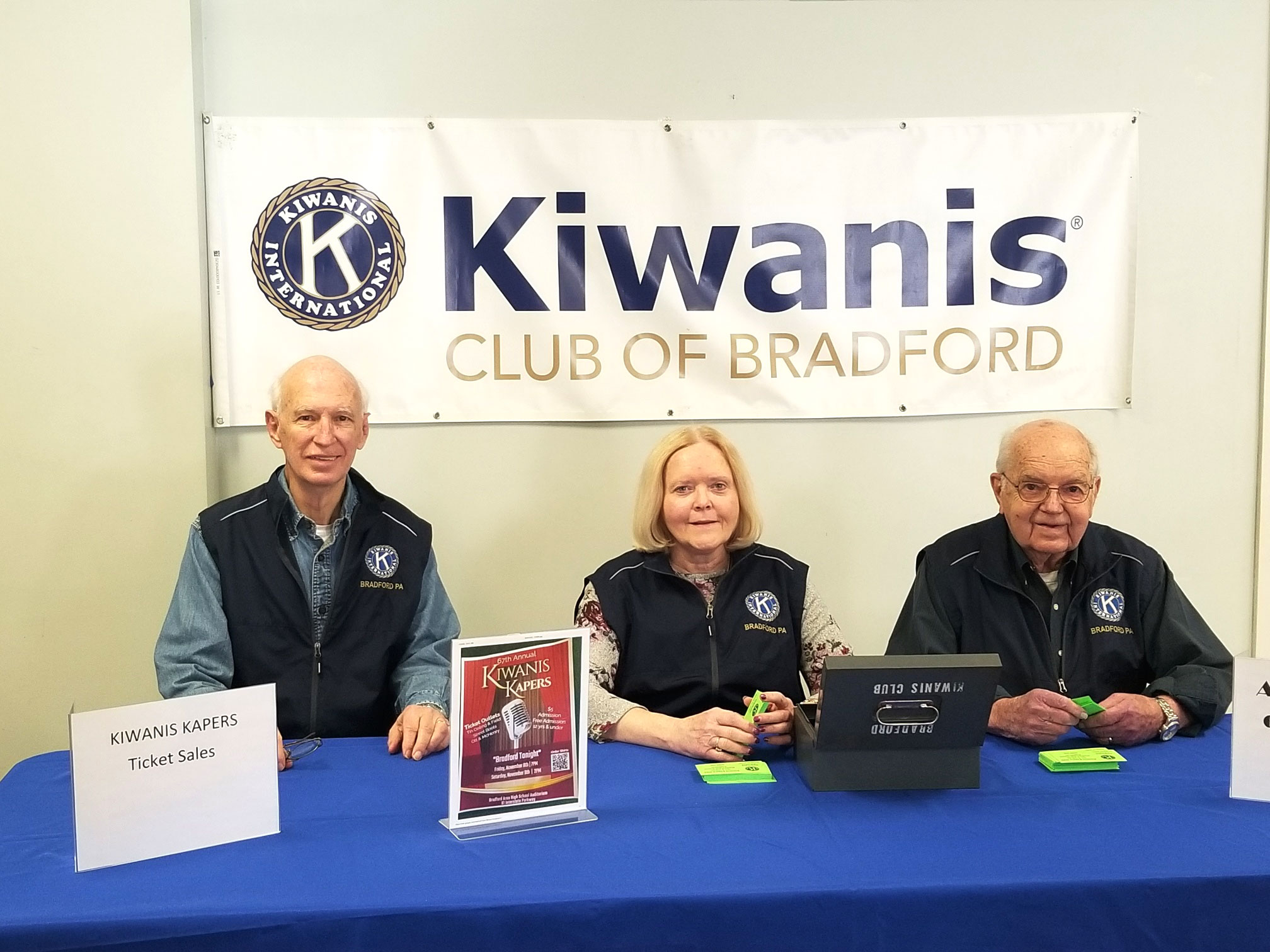 Image of Dr. Dick Dryden, Paula Vecellio and Dean Bauer selling tickets for Kiwanis Kapers | Kiwanis Club of Bradford
